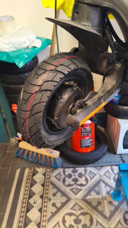 Pneu 10x3-6 monté sur la roue d'une trottinette en atelier